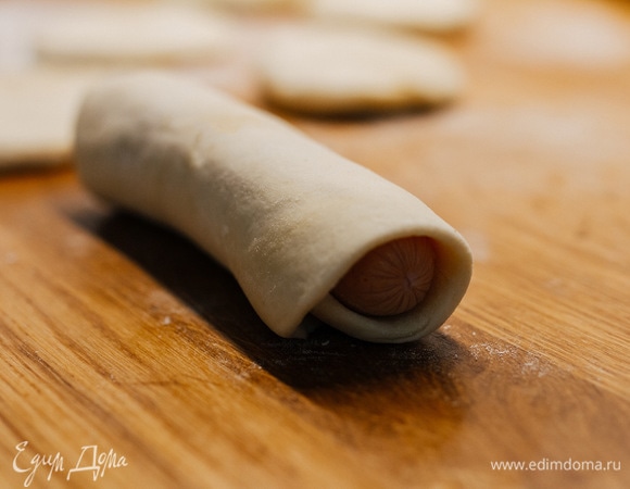 Сосиску положить на край теста и завернуть. Края закрепить.