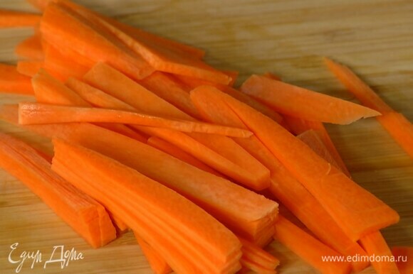 Морковь почистить, нарезать соломкой и добавить к мясу.