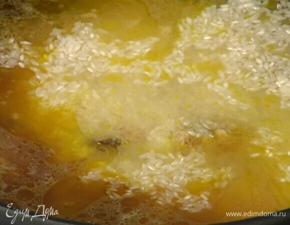 Рис добавить к мясу с овощами, затем влить горячую воду, так чтобы она покрывала все на палец.