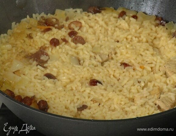 Уменьшить огонь, накрыть вок крышкой и томить рис с мясом 25–30 минут до готовности.