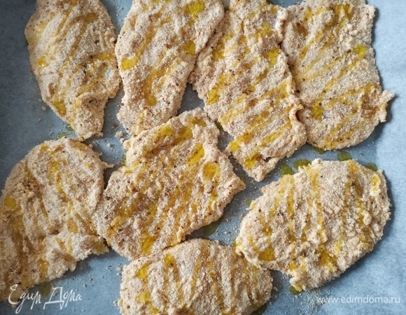 Выложить мясо на противень, предварительно застелив его пергаментной бумагой. Сверху полить оливковым маслом и отправить в предварительно разогретую до 180°C духовку на 25–30 минут.