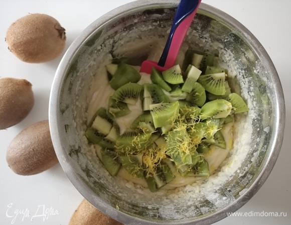 Затем в тесто добавить цедру 1 лимона и 3 киви, предварительно нарезав его небольшими кусочками. Перемешать.