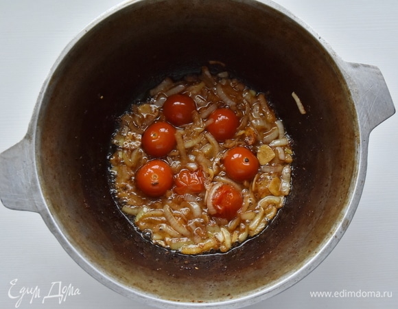 В казан по необходимости добавляю еще немного растительного масла и обжариваю репчатый лук, чеснок и томаты. После чего перекладываю их из казана в чистую миску.