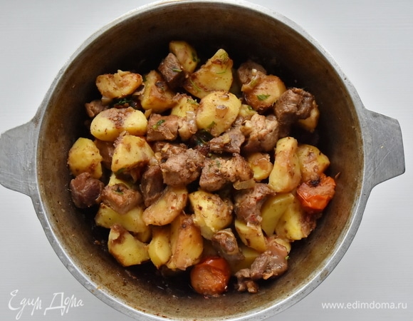 Когда картофель поджарился, перекладываю в казан обжаренное мясо с луком, томатами и чесноком. Аджику развожу небольшим количеством воды, добавляю в казан к мясу с овощами. Аккуратно перемешиваю. Накрываю посуду крышкой, уменьшаю огонь и томлю минут 15–20. При подаче посыпаю оджахури рубленой зеленью.