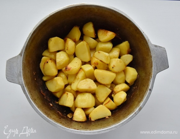 Вливаю в казан оставшееся растительное масло и обжариваю крупно нарезанный картофель до золотистой корочки.