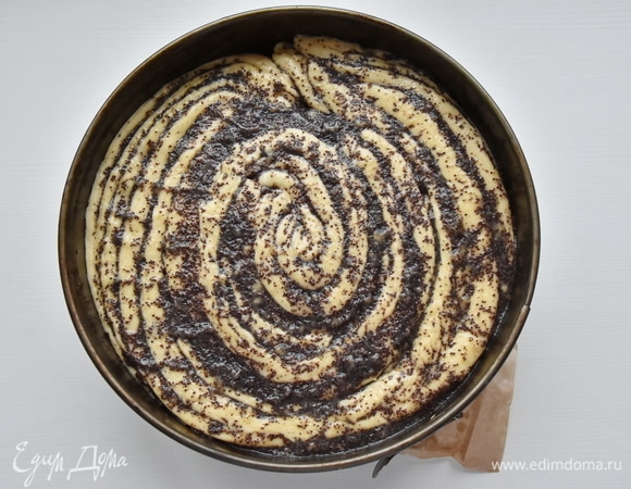 Форму для выпекания выстилаю смазанной небольшим количеством масла пергаментной бумагой. Укладываю половинки макового рулета, сворачивая их улиткой — срезом вверх. В данном случае использую форму диаметром 24 см. Даю время тесту подняться и смазываю верх булки яйцом, смешанным с молоком. Выпекаю булку в духовке, разогретой до 180°C, 40 минут.