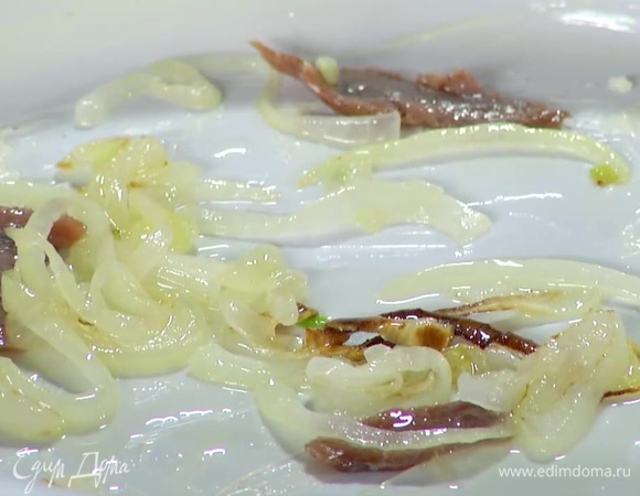 Форму для запекания смазать сливочным маслом, выложить в нее треть разделенных на кусочки анчоусов и треть обжаренного лука.