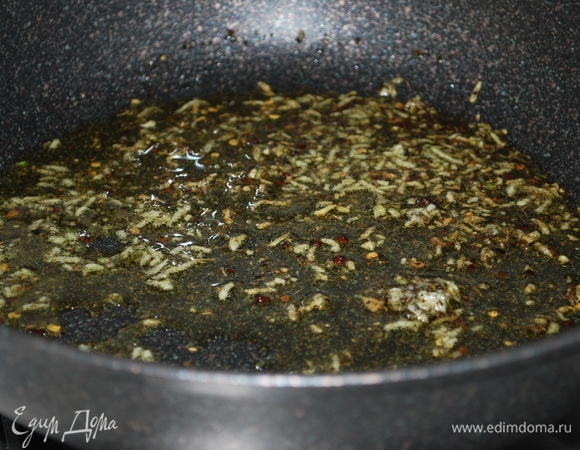 Чеснок очистите, натрите на мелкой терке. В глубокой сковороде разогрейте оливковое масло, добавьте орегано и чеснок, прогрейте все вместе 20–30 секунд.