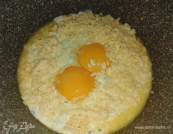 В разогретую сковороду со сливочным маслом выложить творожно-белковую массу. Посыпать натертым сыром. Сверху выложить желтки.