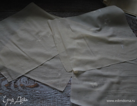 Тесто фило разрежьте на квадраты и, перед тем как выложить в форму, смажьте маслом по желанию.