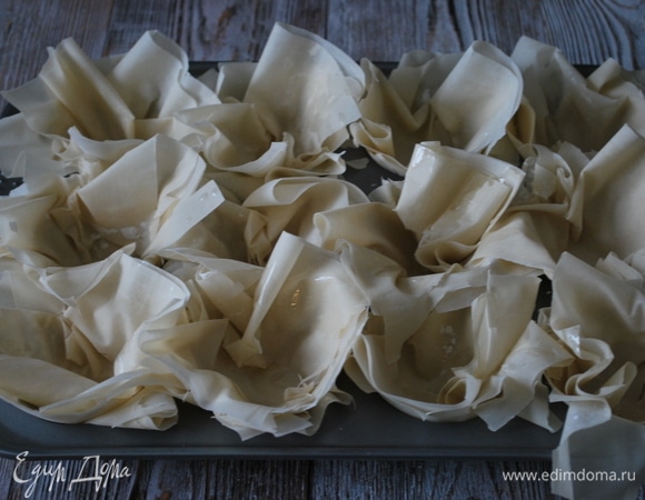 Форму для выпечки смажьте маслом (у меня форма для кексов, 12 шт.). Тесто фило выложите в формочки по 4–6 листов в каждую.