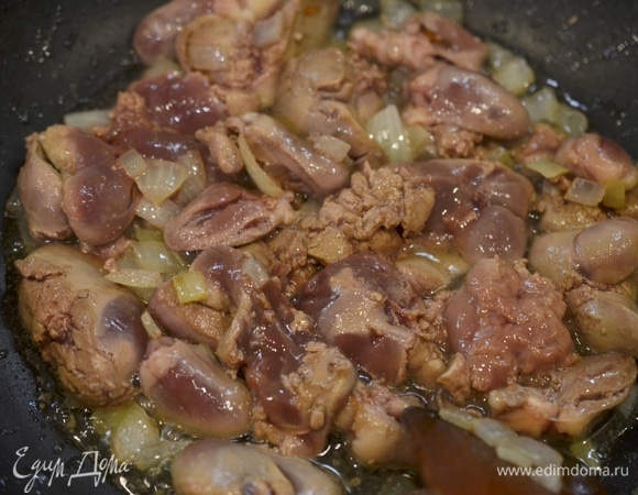 Добавьте печень и сердечки, обжаривайте все вместе минут 5–7.