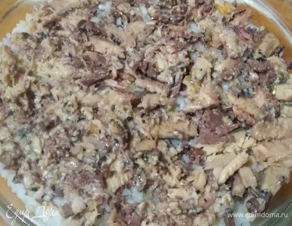 С рыбы слить жидкость. Размять вилкой, уложить поверх риса.