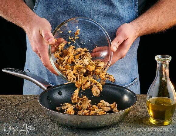 В сковороде разогрейте оливковое масло и выложите мидии.