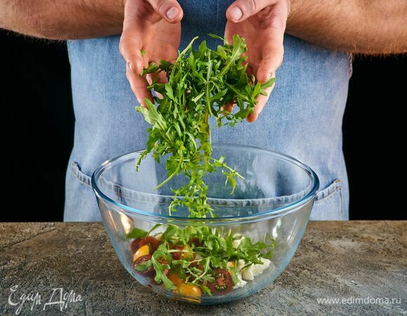 В салатник выложите руколу, помидоры черри и моцареллу.