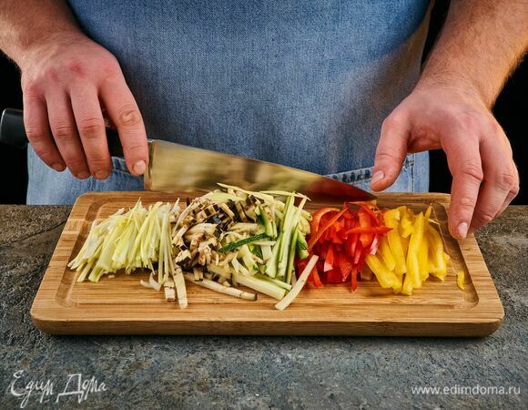 Болгарский перец, цукини и баклажаны нарежьте соломкой. Лук-порей — тонкими ломтиками. Чеснок мелко порубите. 