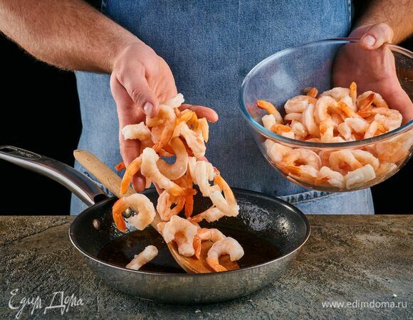 Креветки выложите в апельсиново-карамельную смесь и посолите. Готовьте около 5 минут.