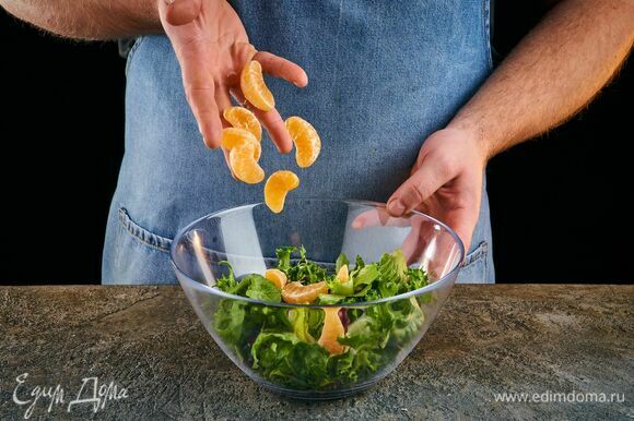 В чашу выложите салатный микс, креветки в миндальных лепестках, дольки мандарина. Полейте соусом и перемешайте.