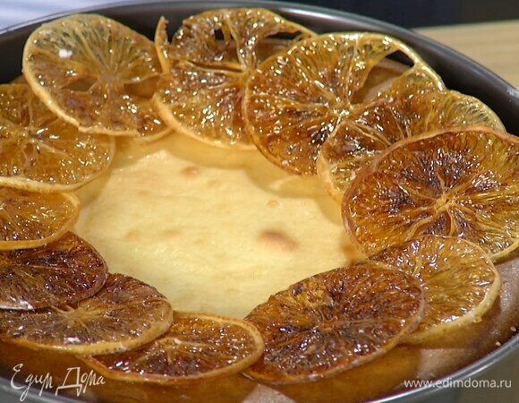 Выложить начинку на охлажденный корж, разровнять и выпекать чизкейк в разогретой до 160°С духовке 50–60 минут, затем слегка остудить и украсить лимонными чипсами.