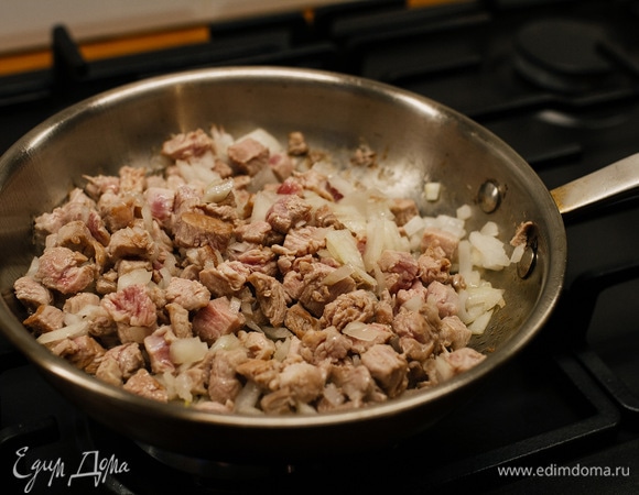 Овощи, лук и мясо нарезать кубиками. На сковороде раскалить растительное масло, выложить мясо и лук. Обжаривать 2–3 минуты.