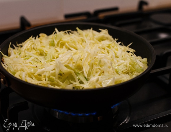Капусту мелко нашинковать, влить немного воды и тушить на сковороде 3–5 минут. Добавить соль, перец по вкусу.
