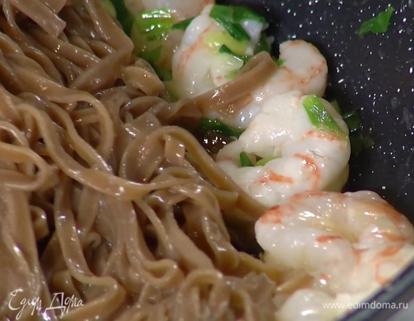 Отправить в сковороду с креветками отваренную лапшу и все прогреть.