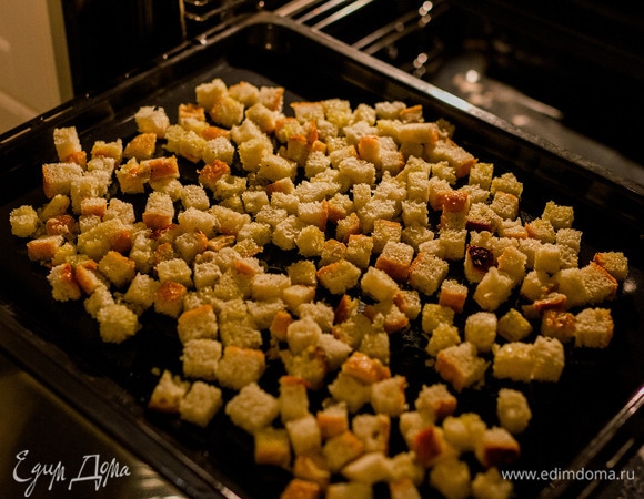 Хлеб нарезать мелкими кубиками, смешать с маслом и выложить на противень. Запекать при 180°C до золотистого цвета, иногда перемешивая.
