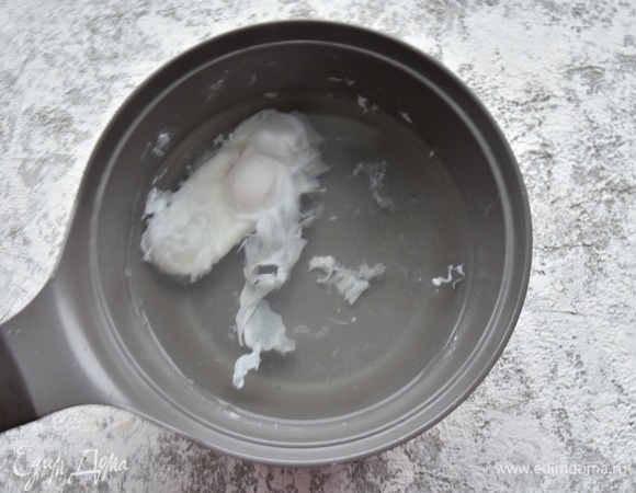 В кастрюле довожу до кипения воду, солю и вливаю 1 ч. л. столового уксуса. Ложкой перемешиваю кипящую воду, создавая в центре воронку. Вливаю в центр воронки яйцо. Варю 2–3 минуты. Шумовкой извлекаю яйцо из кастрюли.