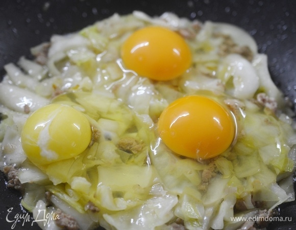 Вбейте яйца. Можно сохранить желток целиковым или распустить его.