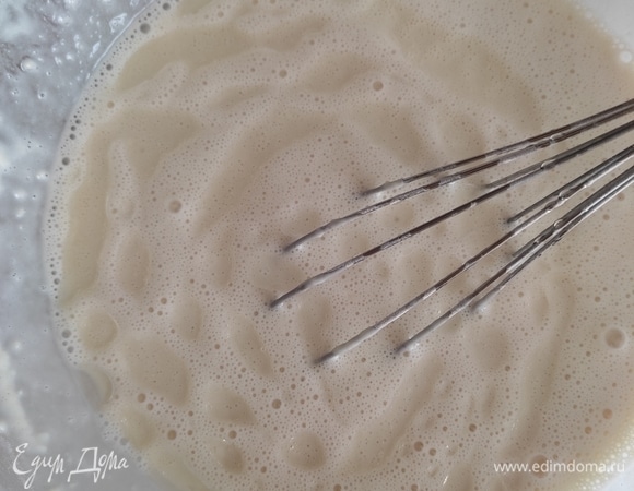 Добавить муку, тщательно перемешать тесто до однородности. Муки может потребоваться чуть больше или меньше. Тесто должно быть негустым, текучим. Добавить растительное масло и еще раз перемешать.