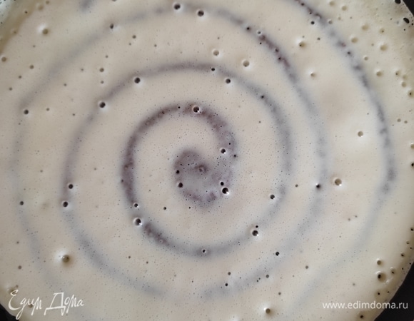 Через 5 секунд, как только шоколадная спираль схватится, наливаем основное тесто и распределяем по сковороде. Обжариваем с одной стороны.