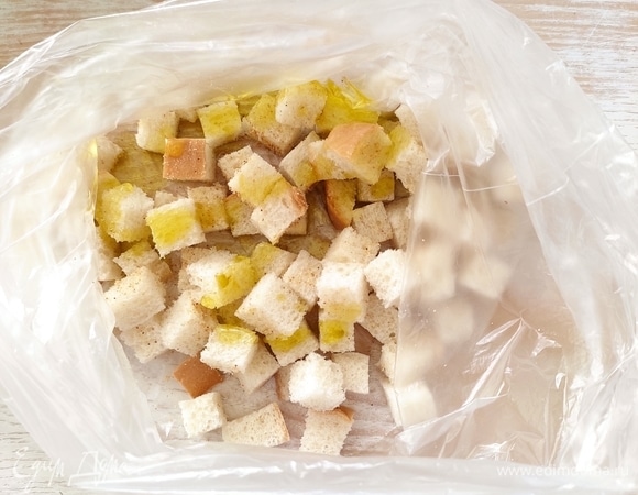 Затем поместим в полиэтиленовый пакет, добавим туда сухой чеснок и 1 ст. ложку оливкового масла. Закроем пакет и немного потрясем, чтобы чеснок и масло равномерно распределились по хлебу.