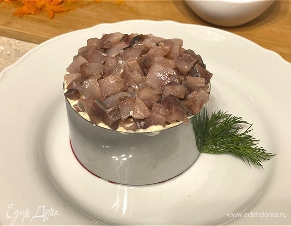 Следующий слой — отварной картофель и измельченный лук. Каждый слой можно немного посолить. Венчает салат сельдь. 