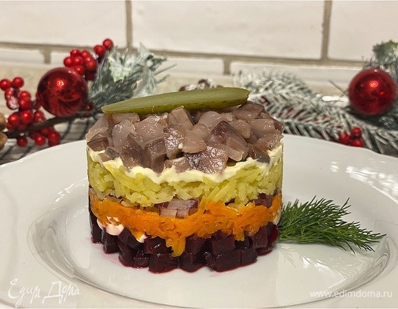 Аккуратно и очень медленно снимите кулинарное кольцо, не повредив слои. Украсьте селедку под шубой по желанию. У меня — немного укропа и маринованный огурец.