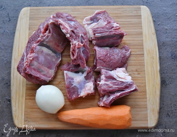 Для приготовления бульона буду использовать говяжьи ребра на косточке. Заливаю мясо холодной водой, туда же кладу морковь и луковицу целиком, черный и душистый перец горошком. По желанию можно добавить стебли сельдерея, лавровый лист.