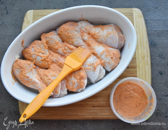 Укладываю ножки в керамическую форму для запекания и с помощью силиконовой кисточки обмазываю их подготовленным маринадом со всех сторон.