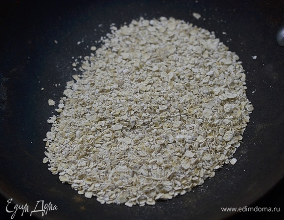 Всыпьте овсянку на сухую сковороду.