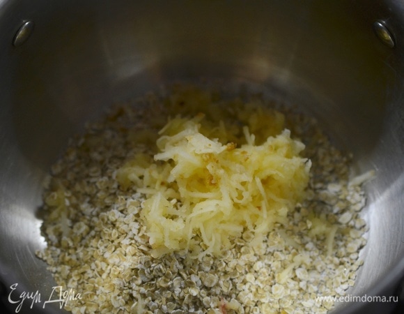 Яблоко почистите, натрите на мелкой терке и добавьте к хлопьям.