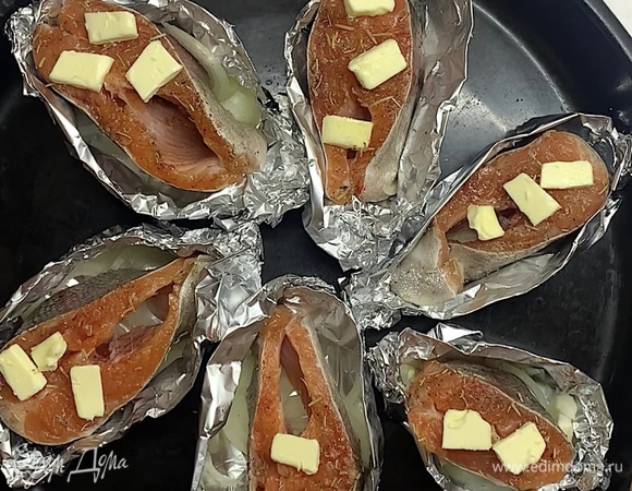 Готовые лодочки с рыбой выкладываем на противень, сверху посыпаем розмарином или тимьяном. Лимоном до приготовления не сбрызгиваем, так рыба потеряет свой цвет. Сливочное масло нарезаем на маленькие кусочки и выкладываем сверху на рыбу.