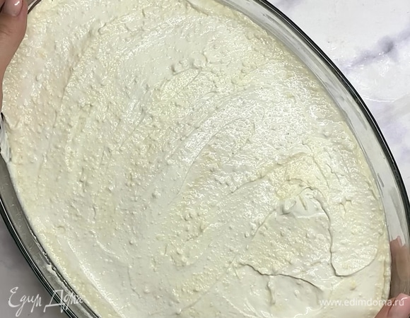 Форму смазываем сливочным маслом и переливаем творожную массу. Разравниваем, сверху смазываем 2 ст. л. сметаны. Ставим в разогретую духовку и выпекаем при 180°C 40–50 минут.