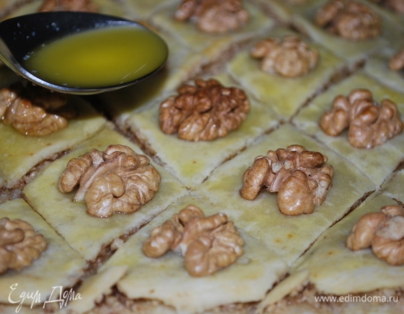 Через 15 минут достаньте противень из духовки, острым ножем углубите разрезы. Растопленным сливочным маслом, примерно 70 г, с помощью ложки полейте все разрезы на пахлаве. Выпекайте пахлаву до светло-золотистого цвета 25 минут при 170°C. Следите, чтобы орехи не подгорели.