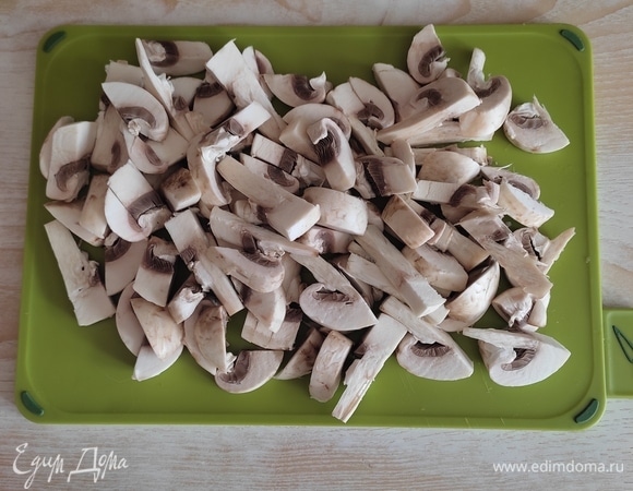 В это время приготовить начинку. Лук нарезать и обжарить до золотистого цвета, добавить нарезанные шампиньоны и обжарить до готовности.