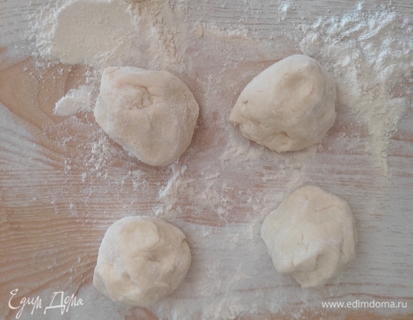 Достать тесто, разделить его на 4 равные части. Каждый кусочек немного припылить мукой и обмять.