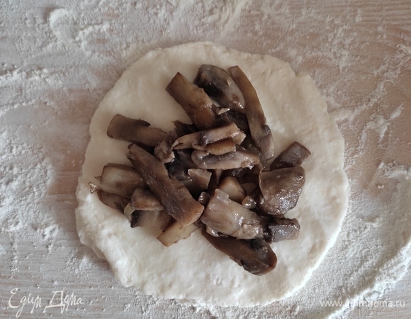 Кусочек теста раскатать в лепешку, выложить на середину грибы, обжаренные с луком.