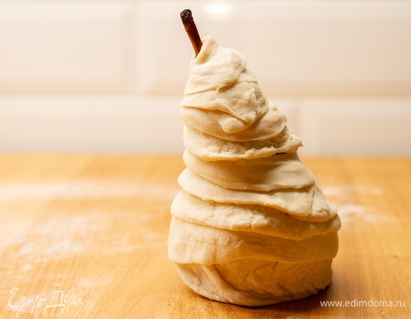 Следующий пласт теста раскатать и нарезать на полоски. Плотно обернуть грушу полосками теста до хвостика. Аналогично повторить со всеми грушами. Поставить на противень, смазать взбитым желтком и отправить в духовку при 180°C на 20–25 минут до золотистого цвета.