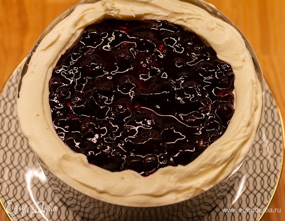 Затем снова сделать бортики из крема, положить оставшийся черничный соус, сверху — крем. Выровнять слой. Накрыть вторым бисквитом. Убрать торт в холодильник под гнет на 2–3 часа.