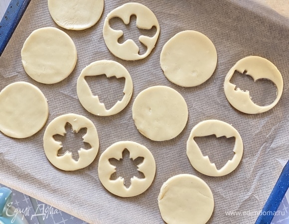 Добавить разрыхлитель и муку и замесить однородное тесто. Раскатать тесто в пласт и вырезать основы для печенек. Выпекать 15 минут при 180°C.