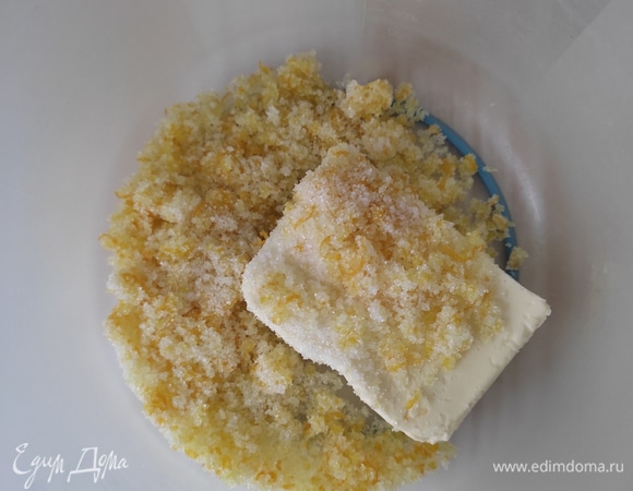 В чашу сложить сливочное масло (обязательно комнатной температуры) и сахар с цедрой, взбить до получения пышной белой массы.