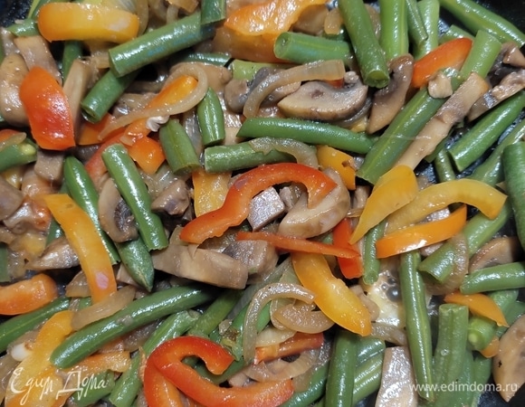 Добавить размороженную стручковую фасоль и нарезанный соломкой болгарский перец. Посолить, перемешать и тушить все вместе до готовности.