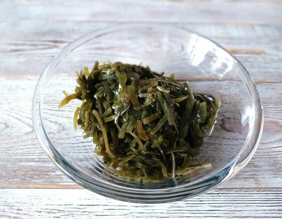 Морскую капусту предварительно откиньте на дуршлаг, чтобы избавиться от лишнего рассола.